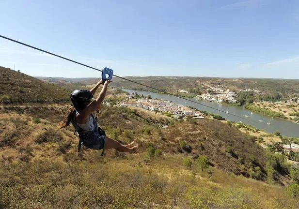 Mulher sai da plataforma de lançamento em San Lucar do Guadiana fazendo um slide até à estação de chegada em Alcoutim.