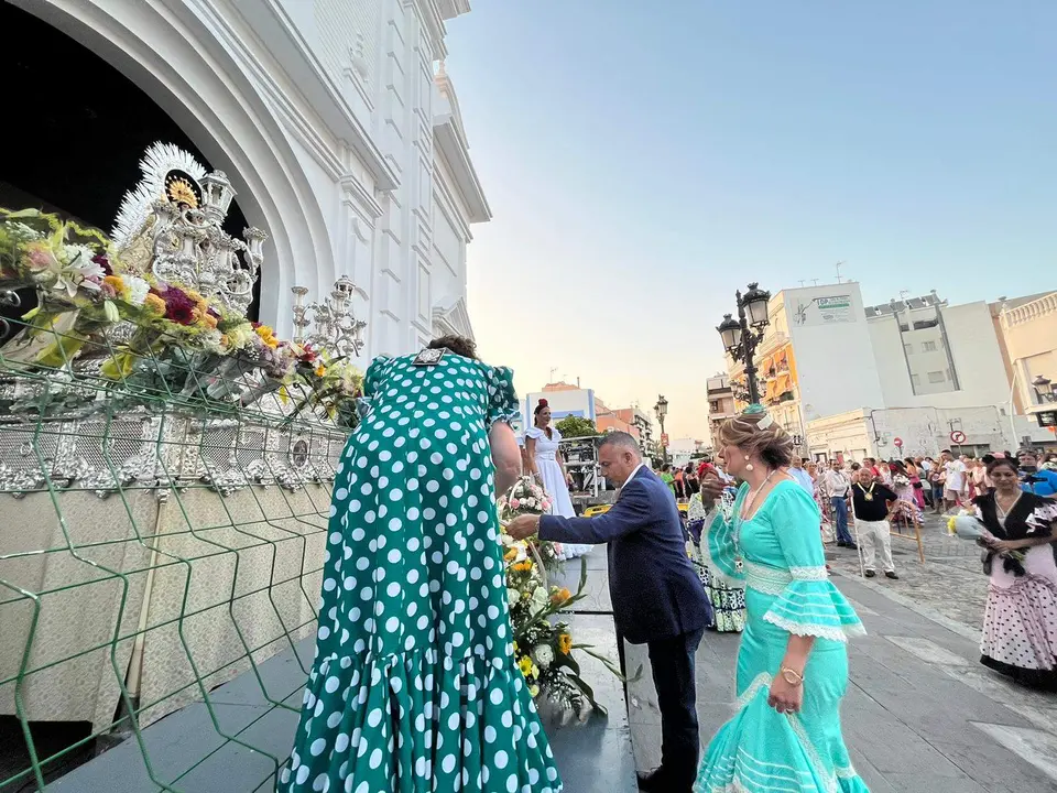 Momento en el que el alcade y al concejala de festejos depositan el canasto de flores a las plantas de la Virgen