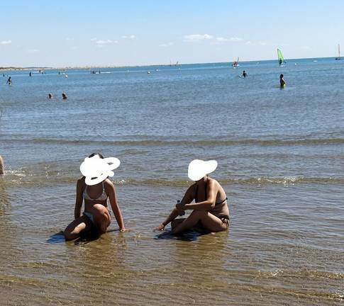 Dos mujeres recogen coquinas en la orilla
