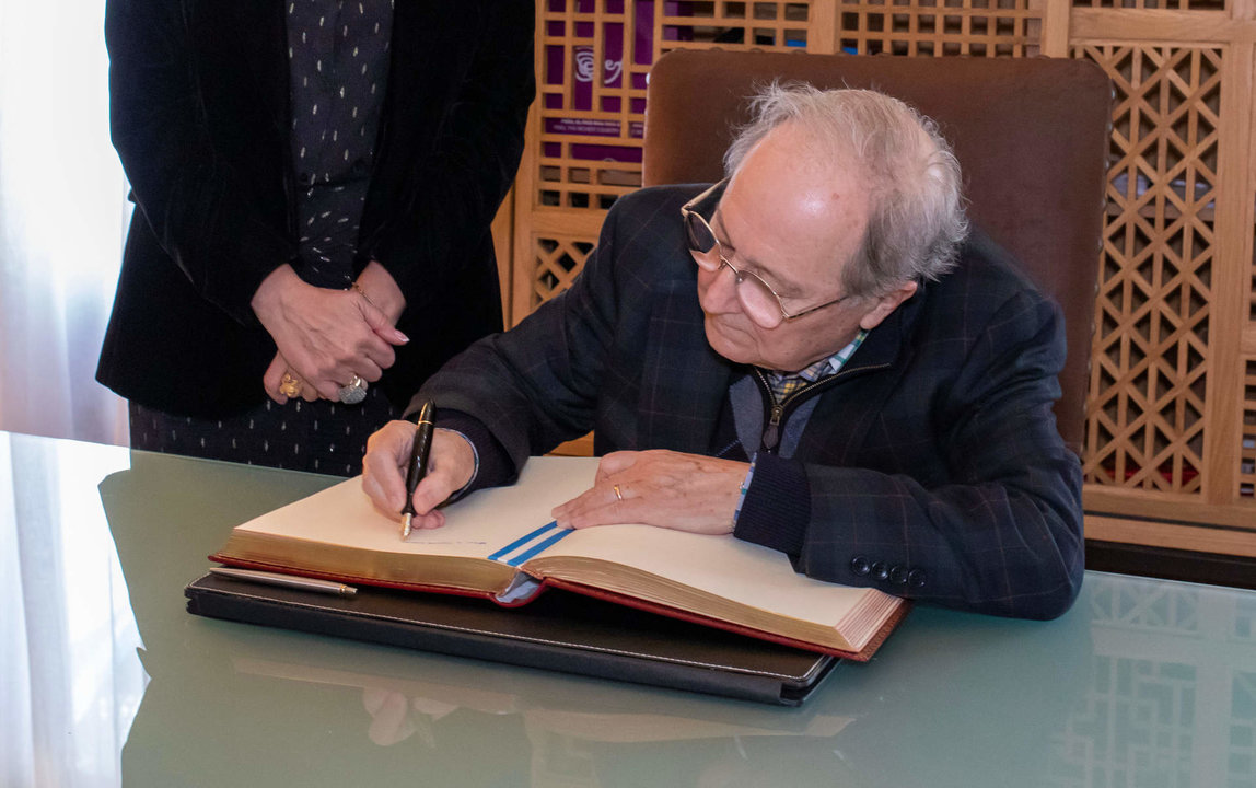 Juan Pérez Mercader, de visita en Huelva firma en el libro de honor del Ayuntamiento