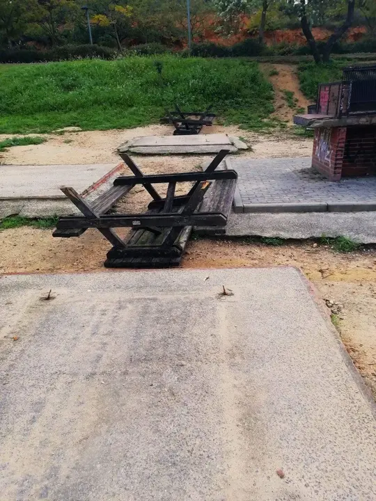 Mesas arrancadas en el parque