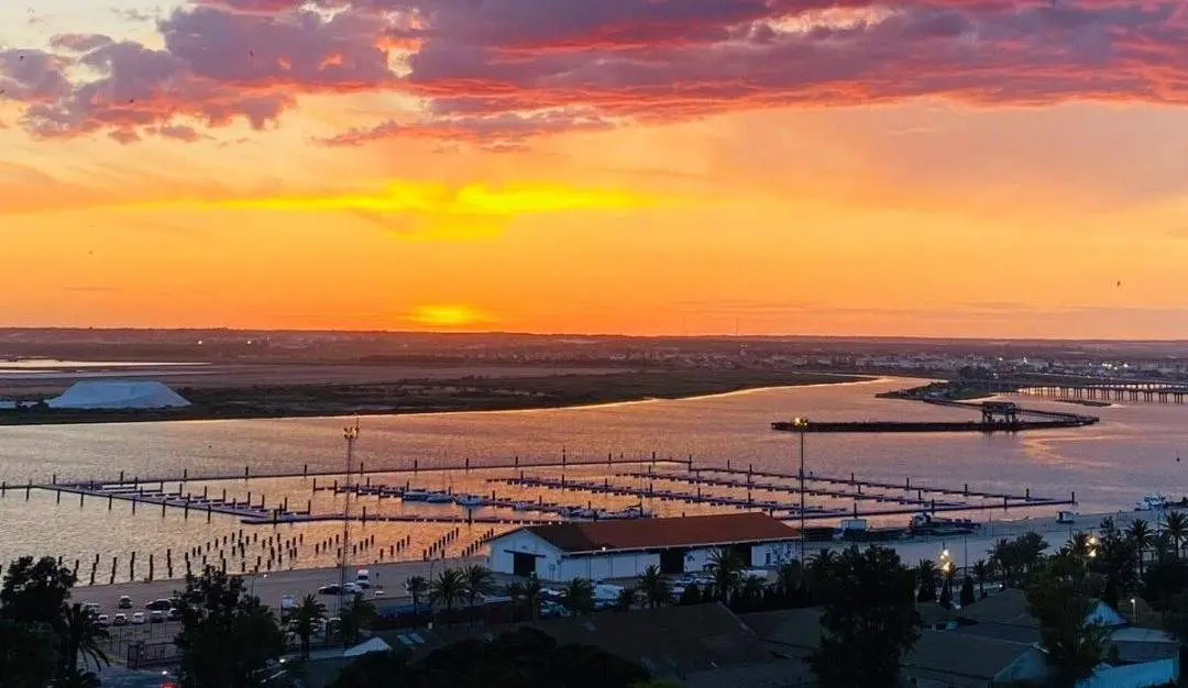 Puesta de sol tras la Marina del Odiel en la capital
