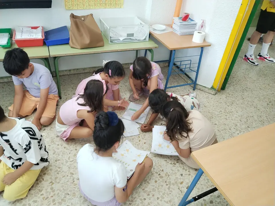 Los pequeños haciendo las tareas en el suelo debido al sofocante calor.