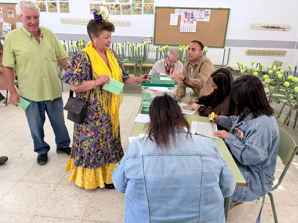 Una mujer vestida con su traje de gitana, ejerciendo su derecho al voto en Beas.