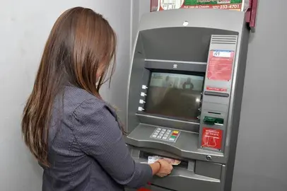 Una mujer saca dinero de un cajero