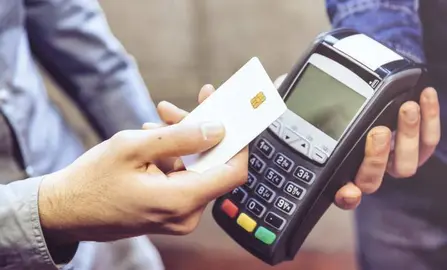 Customer and cashier in a store paying using a contactless card