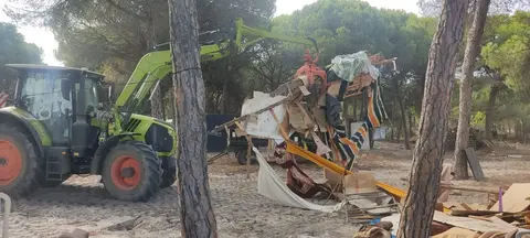 Las grúas destruyen y retiran los restos de las chabolas dentro de los asentamientos en el monte