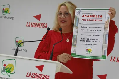Mónica Rossi muestra el cartel de la Asamblea programática de IU Huelva