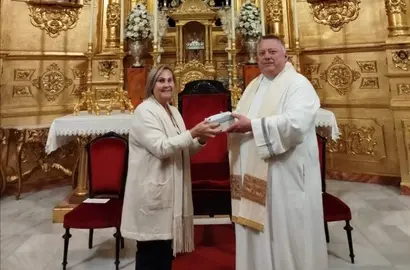 Pili Quesada recibe del párroco Gregorz Korza la mano de la virgen