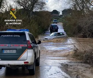 Imagen del vehículo atrapado y auxilio de la Guardia Civil