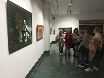 María Sancho explicando a visitantes a la muestra su forma de crear