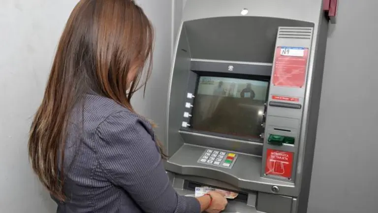 Una mujer saca dinero de un cajero