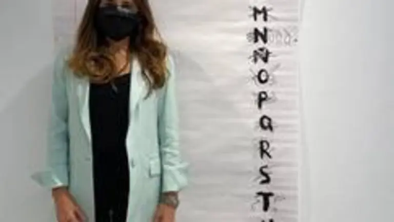 La artista onubense posa delante de una de sus obras en la Universidad