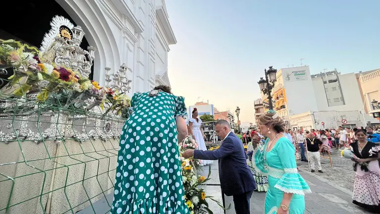 Momento en el que el alcade y al concejala de festejos depositan el canasto de flores a las plantas de la Virgen