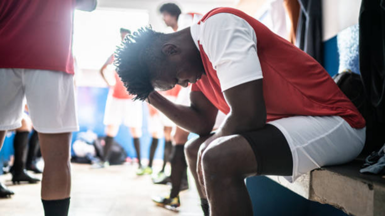 Jugador de f&uacute;tbol concrentrado en el campo, pensando estrategias para el juego.