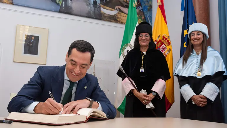 El presidente de la Junta firma en el libro de la UHU