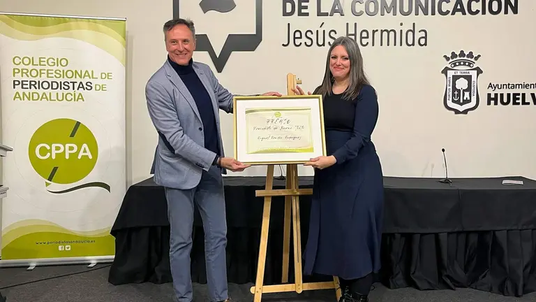 Raquel recibe el premio de manos del presidente del Colegio en Huelva