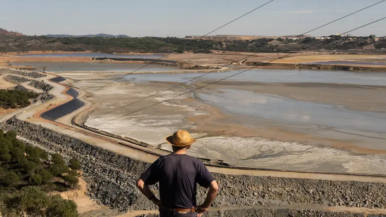 Balsa de residuos mineros en Riotinto, zona crítica

La empresa Atalaya Mining ha pedido a la Junta seguir con la explotación minera de Río Tinto. Ello conlleva verter todos los años 10 millones de metros cúbicos de residuos tóxicos, en unas balsas de estériles mineros ya colmatadas tras años de actividad minera.

La magnitud de estas balsas es colosal. Se trata de los mayores depósitos de estériles mineros de nuestro país. Gossan, Cobre y Aguzadera, son un único conjunto que ocupa 595 hectáreas, con hasta 100 metros de profundidad y que acumulan unos 240 millones de toneladas de lodos tóxicos. Con la pretendida ampliación por parte de la empresa, alcanzarían los 400 millones de toneladas. Esto es, 30 veces el volumen de tóxicos vertidos en el desastre de Aznalcóllar.

Corta Atalaya, corta minera que ha estado funcionando aproximadamente unos 90 años, la iniciaron los ingleses y observamos el "bocado" realizado en la montaña. Ahora en abandono, han roto todos los niveles freáticos, acuíferos y manantiales, el agua se acumula y vemos como sale al nacimiento del río Tintillo, al río Odiel, donde quieren hacer una presa con estas aguas contaminadas para mandarla a los regadíos del entorno de Doñana y la Ría de Huelva.
Escombrera con filtraciones sin control de ningún tipo, aguas rojas que contienen hierro, azufre, arsénico, zinc, cobre... entre otros muchos elementos químicos.
©Greenpeace/PedroArmestre
  
©Greenpeace Handout/PedroArmestre- No sales - No Archives - Editorial Use Only - Free use only for 14 days after release. Photo provided by GREENPEACE, distributed handout photo to be used only to illustrate news reporting or commentary on the facts or events depicted in this image.