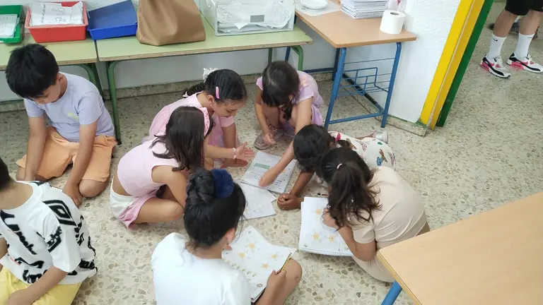 Los pequeños haciendo las tareas en el suelo debido al sofocante calor.