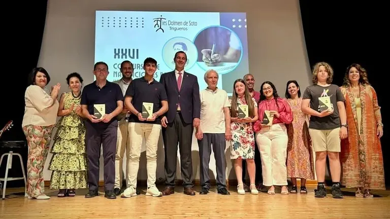 Foto de familia de los premiados y del alcalde y concejal de Educacion de Trigueros con los profesores de IES Dolmen de Soto