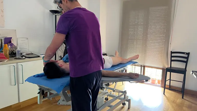 Un fisioterapeuta da una sesi&oacute;n a un paciente