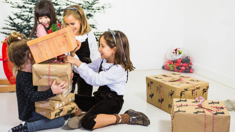 Ni&ntilde;os y ni&ntilde;as abren sus regalos.