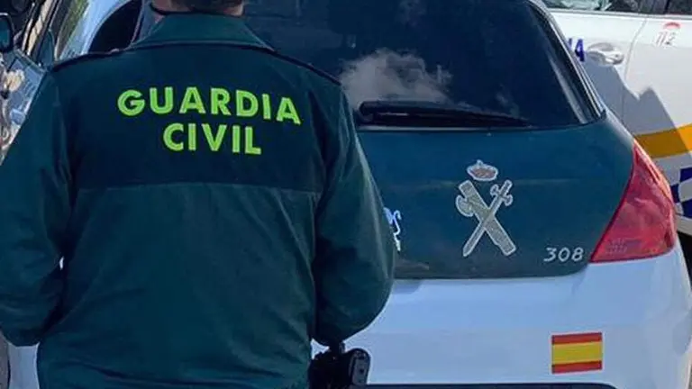 (Foto de ARCHIVO)
Archivo - Un agente de la Guardia Civil junto a un veh&iacute;culo oficial.

REMITIDA / HANDOUT por GUARDIA CIVIL
Fotograf&iacute;a remitida a medios de comunicaci&oacute;n exclusivamente para ilustrar la noticia a la que hace referencia la imagen, y citando la procedencia de la imagen en la firma
11/6/2021