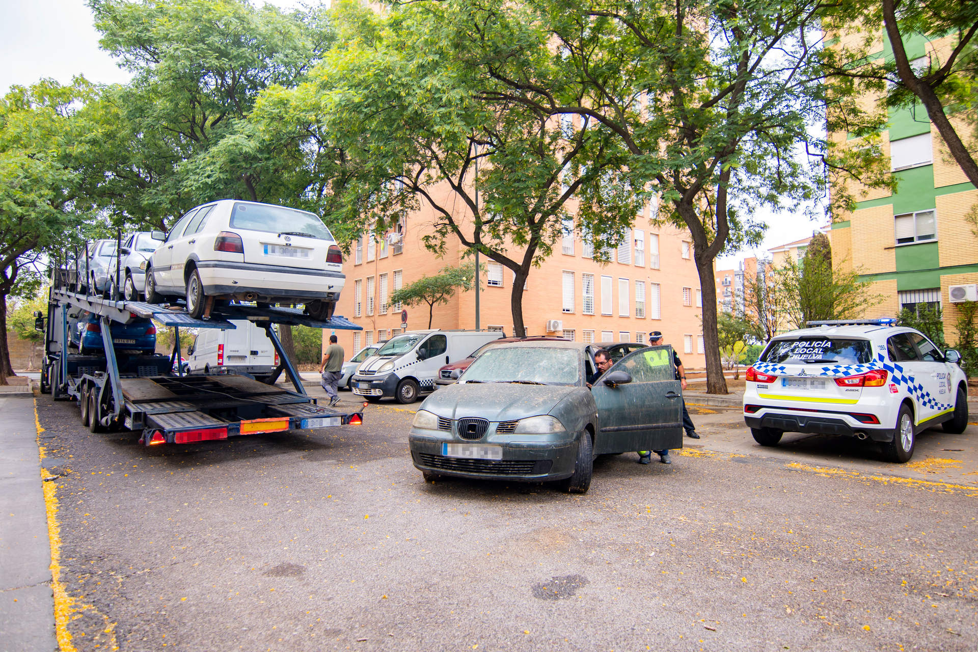 La Policía empuja uno de los vehículos para subirlo a la grúa
