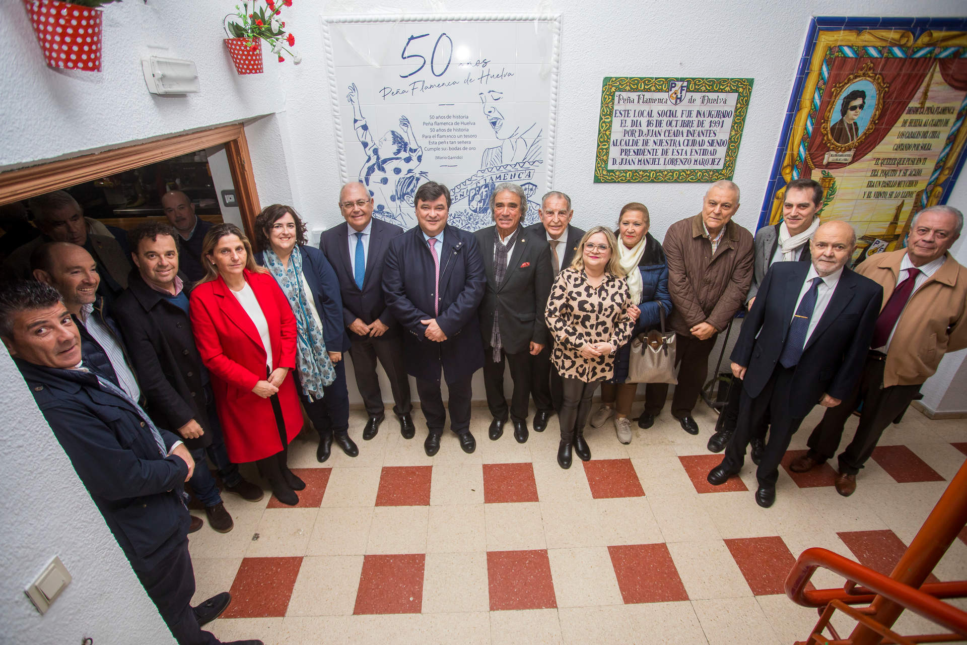 Invitados y participantes ante el azulejo de la Peña Flamenca