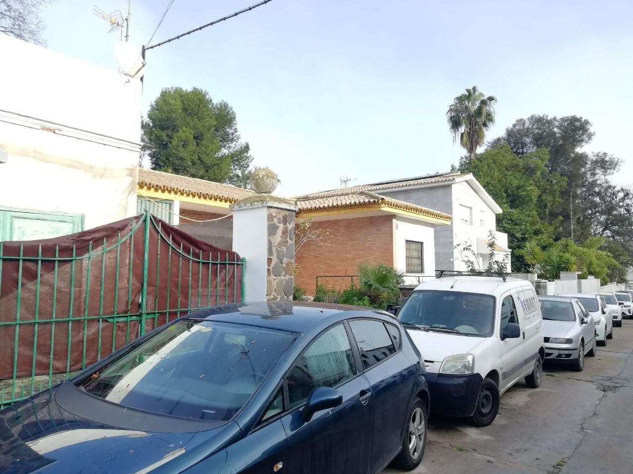 Coches tapando las entradas de las casas en la calle Gibraleón