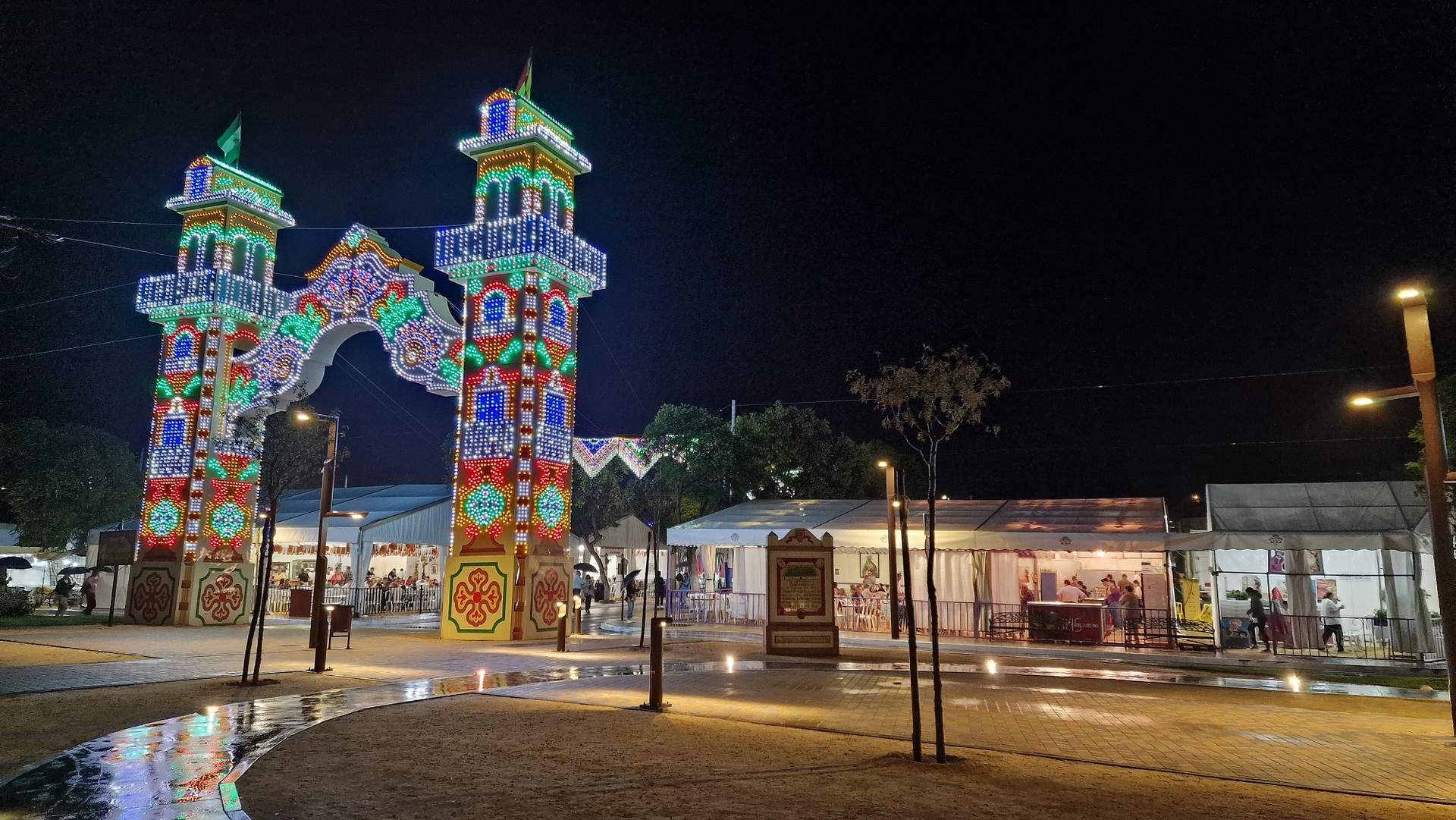 La portada de la Feria iluminada y pasada por agua anoche