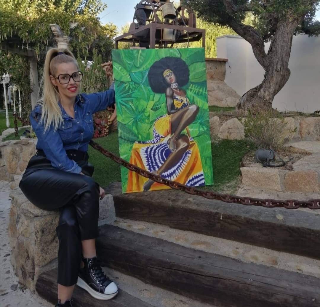 Con una de sus obras pictóricas