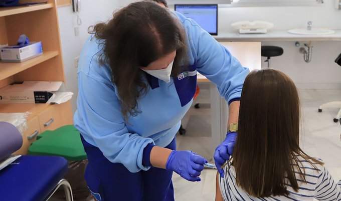 Una enfermera vacuna a una niña