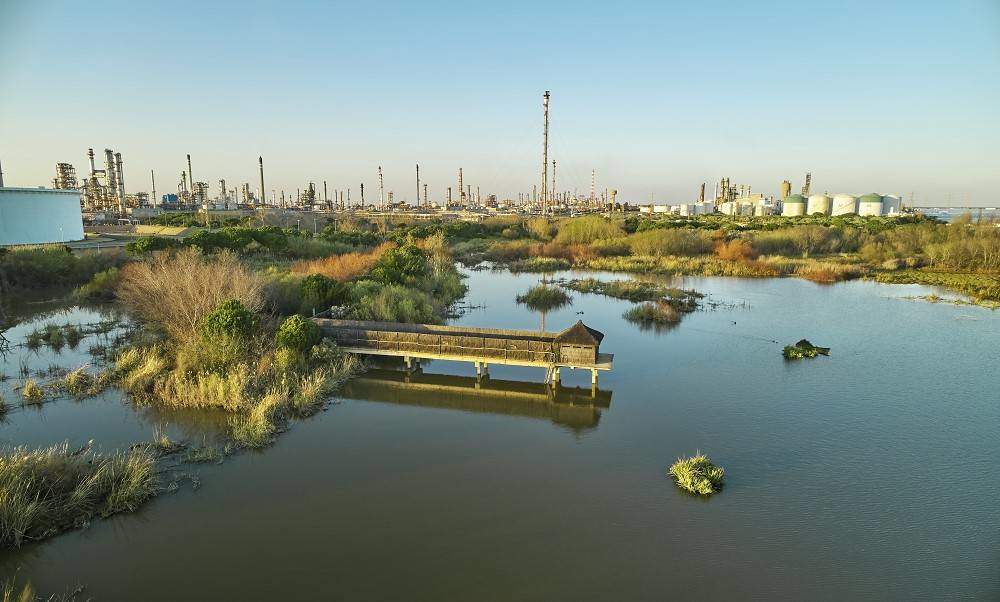 Al fondo, instalaciones de Cepsa en Huelva