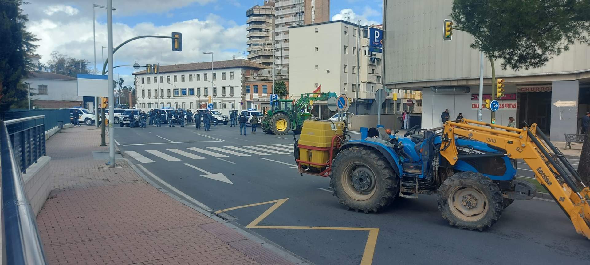 Un tractor embolsado para evitar su avance, al fondo efectivos policiales desplegados