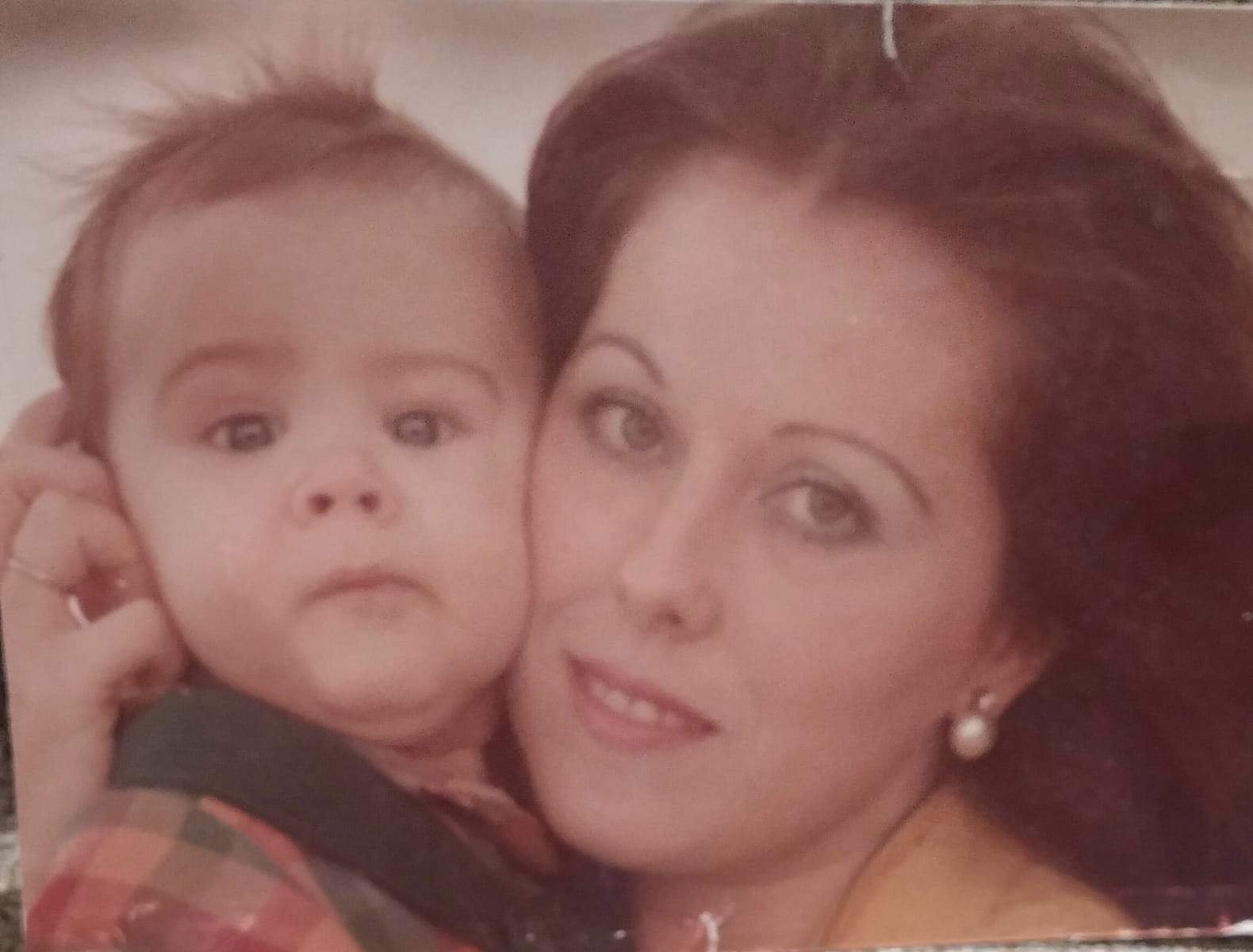 En los brazos de su madre Elena en su infancia