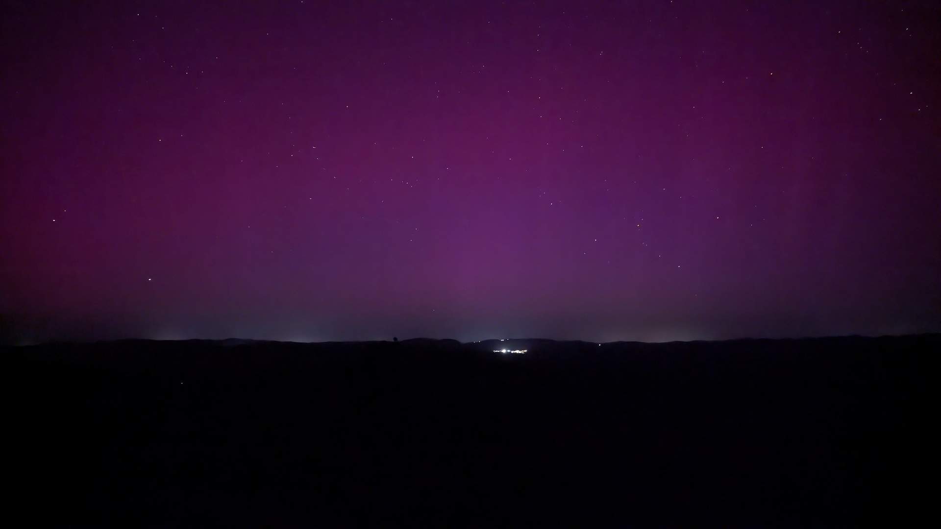 El cielo serrano, iluminado por la aurora boreal vista desde la serranía onubense.