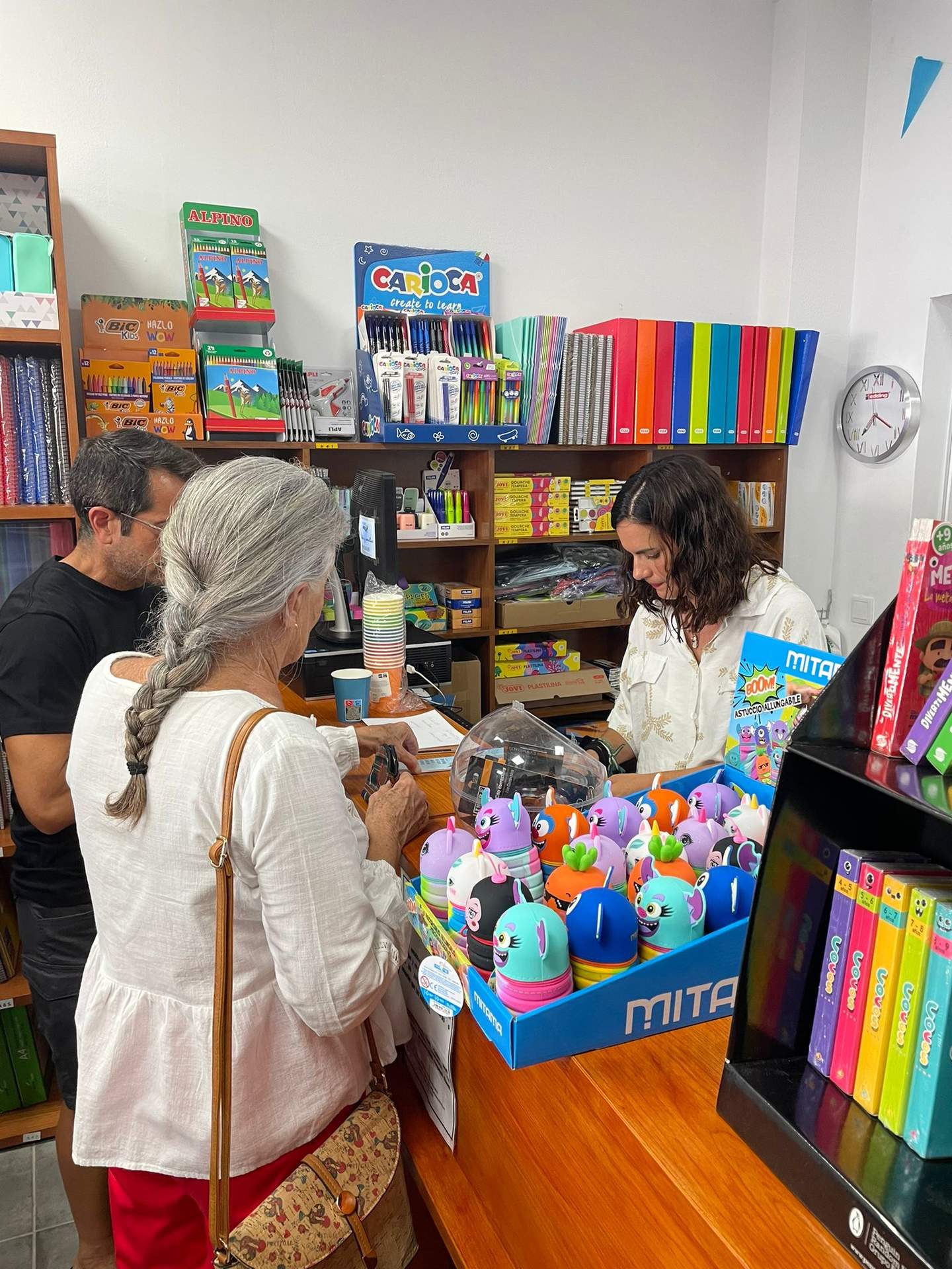En la librería atendiendo a una clienta
