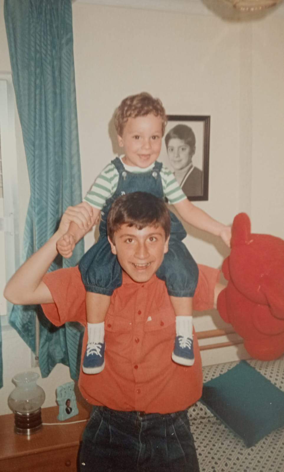 Antonio de niño portando a hombros a Ale, hijo de su prima Meli