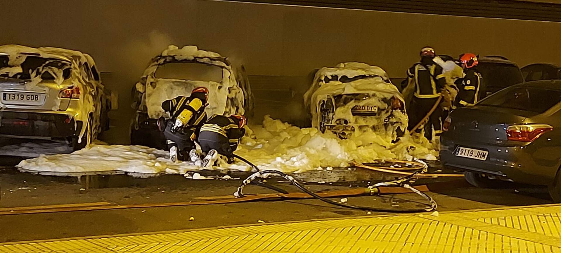 Varios agentes de Bomberos sofocan las llamas bajo el edificio de la Junta de Andalucía
