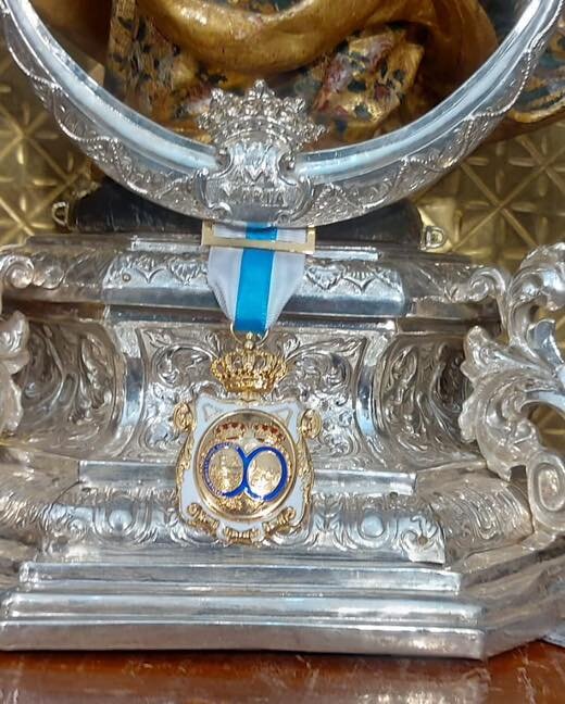 Imagen de la medalla de la Diputación a los pies de la Virgen de la Cinta / Diputación de Huelva.