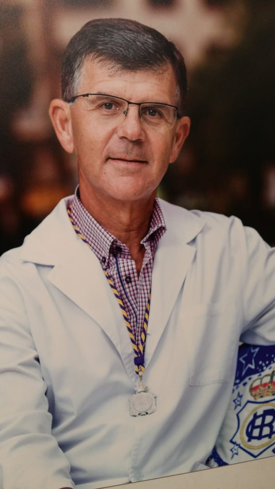 En la consulta con su bata y el escudo del Recre