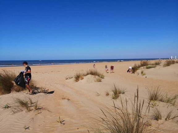 Veraneantes recogen residuos en la playa de Punta Umbría