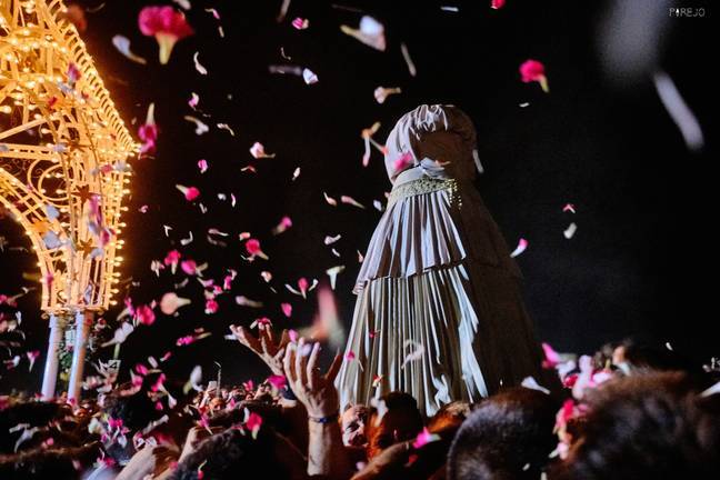 Petalada de flores durante el traslado de la Virgen ya con el capote.